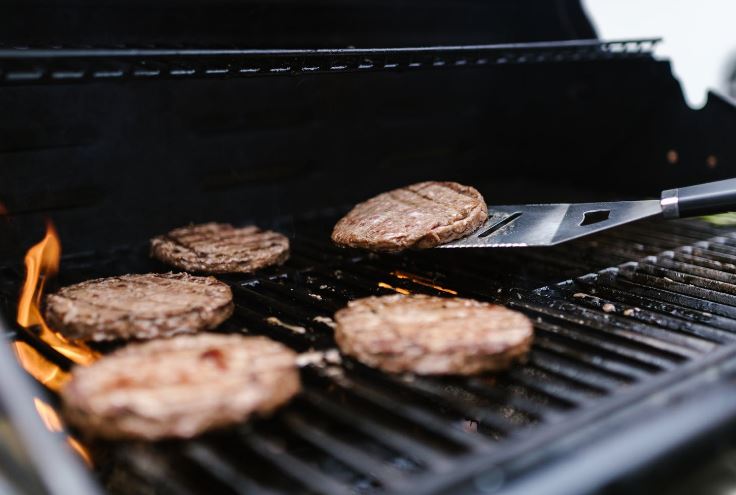 burgers on a grease grill grate