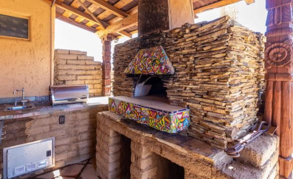 spanish style kitchen with bright colored tiles and carved wood posts