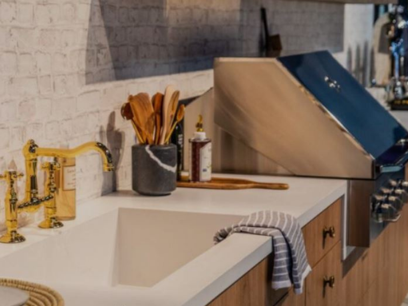 outdoor kitchen with wood cabinetry and white countertops