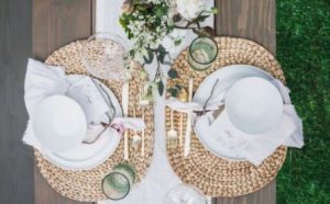 White china on woven mats on outdoor picnic table