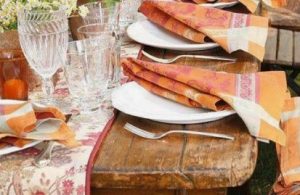 Dinner outdoors on rustic table with white china