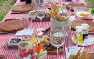 Red and White tablecloth on outdoor table with wood and burlap serveware