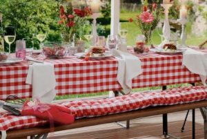 large outdoor dining table with red and white checked decor