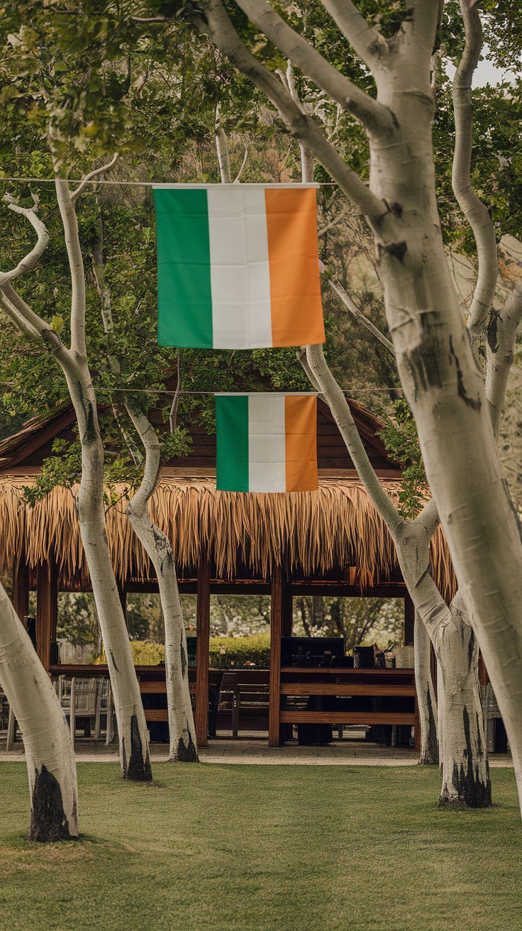 Two Irish flags hanging between trees in an outdoor setting.