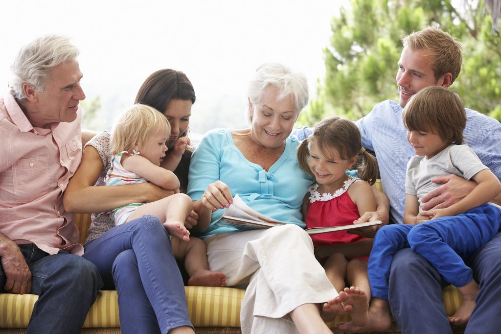 family reading story outside at a grandparents day party