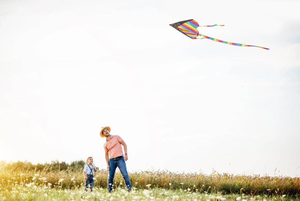 grandfather and child flying a kite